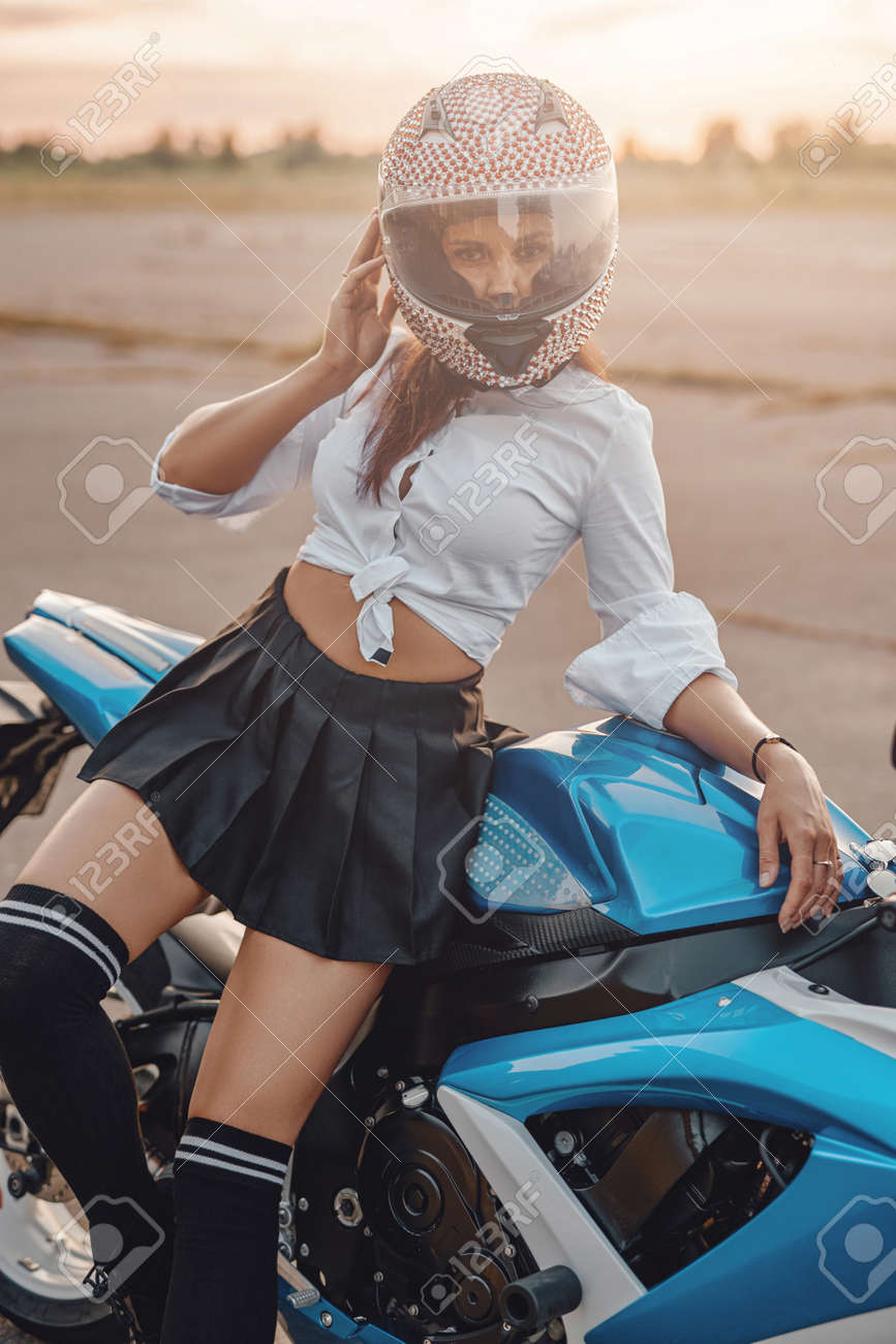 172372201-shot-of-seductive-woman-wearing-stockings-and-helmet-with-motorbike-on-country-road.jpg